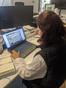 A lady looks at a computer screen with a image of a project on the screen. 